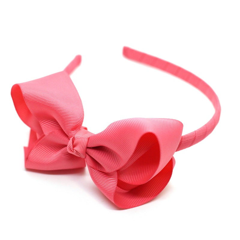 Adorable Alice Bow Headband in Coral. Perfect to complete an outfit or to dress up